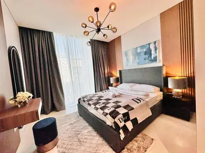 a bedroom with a large bed and a chandelier at Burj Khalifa View Modern 2BR CVG in Dubai