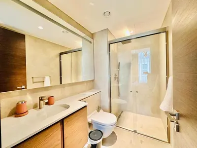 a bathroom with a shower and a toilet and a sink at Burj Khalifa View Modern 2BR CVG in Dubai
