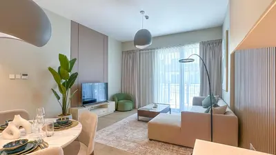 a living room with a couch and a table and a tv at Peaceful 1BR in La Serine, Lush Garden Views - 1AB02 in Dubai