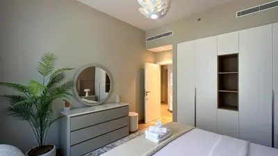 a bedroom with a large mirror and a plant at Peaceful 1BR in La Serine, Lush Garden Views - 1AB02 in Dubai