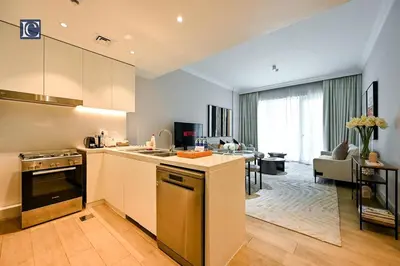 a kitchen and living room with a couch and a table at Luxury Escapes - Stylish 2-Bedroom Haven in La Cote, Port de La Mer in Dubai