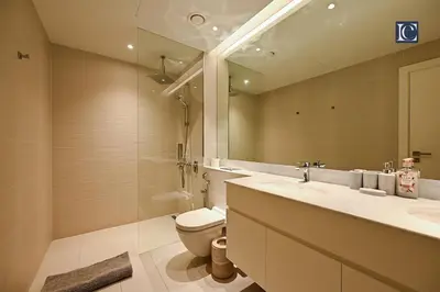 a bathroom with a toilet and a sink and a mirror at Luxury Escapes - Stylish 2-Bedroom Haven in La Cote, Port de La Mer in Dubai