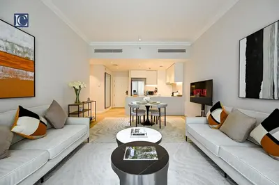 a living room with a couch and a table at Luxury Escapes - Stylish 2-Bedroom Haven in La Cote, Port de La Mer in Dubai