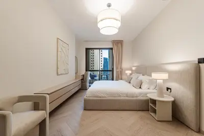 a white bedroom with a bed and a couch at Cozy Beachside 1-bedroom in Murjan in Dubai
