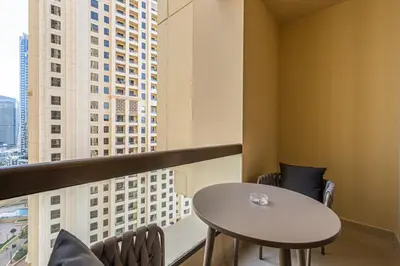 a table and chairs in a room with a window at Cozy Beachside 1-bedroom in Murjan in Dubai