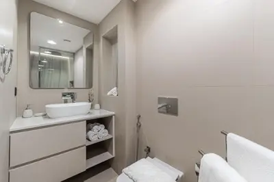 a white bathroom with a sink and a mirror at Cozy Beachside 1-bedroom in Murjan in Dubai