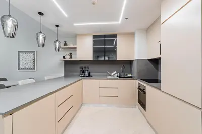 a kitchen with white cabinets and stainless steel appliances at Cozy Beachside 1-bedroom in Murjan in Dubai