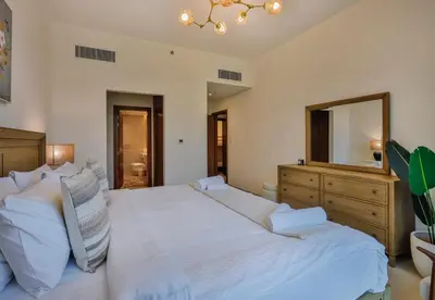 a bedroom with two beds and a large mirror at Burj Khalifa View - 2BR with Maids room in Canal Front 1, Al Wasl - Allsopp & Allsopp in Dubai