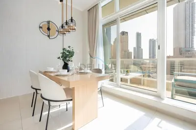 a dining room with a table and chairs and a large window at Sea and City View 1BR, Close to Marina Beach, Botanica Tower, Dubai Marina by Deluxe Holiday Homes in Dubai