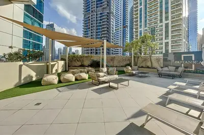 a patio with couches and chairs in a city with tall buildings at Sea and City View 1BR, Close to Marina Beach, Botanica Tower, Dubai Marina by Deluxe Holiday Homes in Dubai