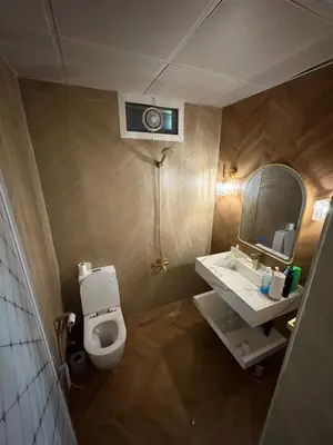 a bathroom with a white toilet and a mirror at Barsha South Cozy Guesthouse in Dubai