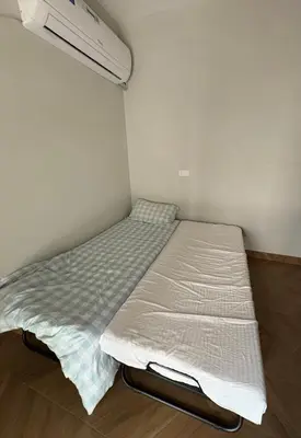 a bed in a corner of a room at Barsha South Cozy Guesthouse in Dubai