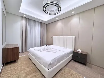 a bedroom with a large white bed and a chandelier at CaiCai Homes 1 BHK Nobles Tower Business Bay 5 min Drive to Dubai Mall in Dubai