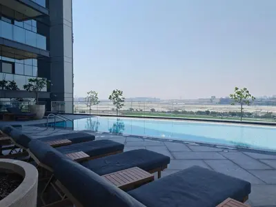 a swimming pool with lounge chairs and a building at CaiCai Homes 1 BHK Nobles Tower Business Bay 5 min Drive to Dubai Mall in Dubai