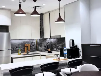 a kitchen with white cabinets and black and white appliances at CaiCai Homes 1 BHK Nobles Tower Business Bay 5 min Drive to Dubai Mall in Dubai