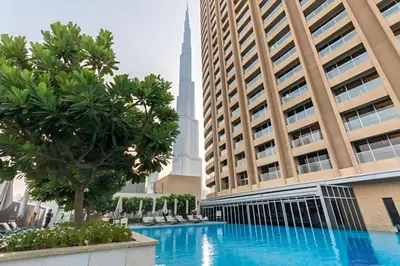 a swimming pool in front of a tall building at Durrani Homes - Dubai Mall Fashion Avenue in Dubai