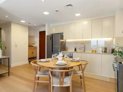 a kitchen and dining room with a table and chairs at The Town Square Suite Luxury 2BR Near Qudra Lake in Dubai