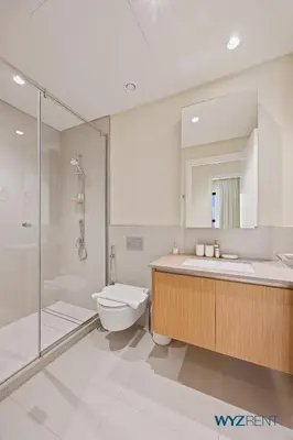 a bathroom with a toilet and a sink and a shower at Pink Panther Soft Glam 1BR in Surf 2-Creek Beach in Dubai