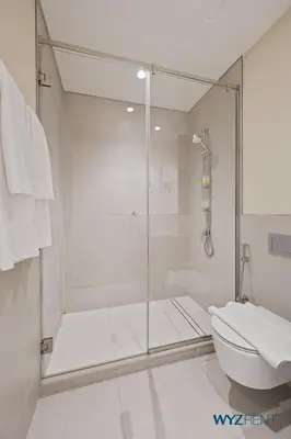a bathroom with a glass shower and a toilet at Pink Panther Soft Glam 1BR in Surf 2-Creek Beach in Dubai