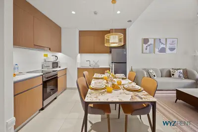 a kitchen and living room with a table and chairs at Earthy Elegant 1BR, Surf 2 Creek Beach Access in Dubai