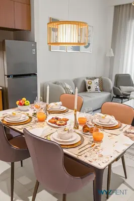 a dining room table with plates of food on it at Earthy Elegant 1BR, Surf 2 Creek Beach Access in Dubai