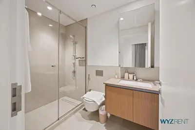 a bathroom with a shower and a toilet and a sink at Earthy Elegant 1BR, Surf 2 Creek Beach Access in Dubai