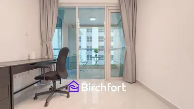 an office with a desk and a chair next to a window at Stylish Stay Steps from the Marina in Dubai