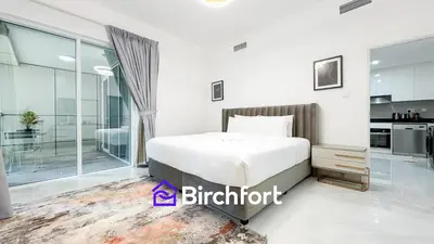 a bedroom with a bed and a kitchen at Stylish Stay Steps from the Marina in Dubai
