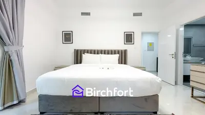 a bedroom with a bed with a white bedspread at Stylish Stay Steps from the Marina in Dubai