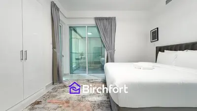 a bedroom with a bed and a sliding glass door at Stylish Stay Steps from the Marina in Dubai