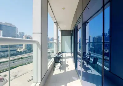 a balcony with tables and chairs on a building at Damac Paramount Tower in Dubai