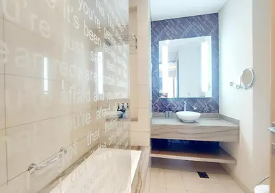 a bathroom with a tub and a sink and a mirror at Damac Paramount Tower in Dubai