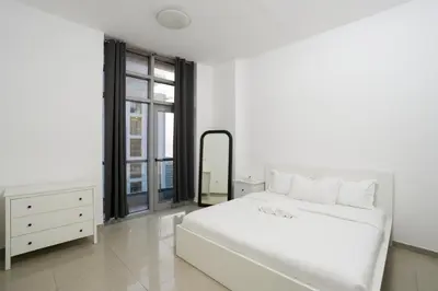 a white bedroom with a large white bed and a mirror at Great Flat Near Marina & Beach With Amazing View, Many Activities in Dubai
