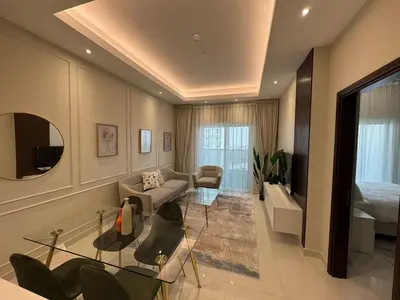 a living room with a couch and a table at Elegant One Bedroom in Sports City in Dubai
