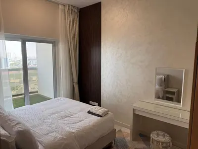 a bedroom with a bed and a desk with a window at Elegant One Bedroom in Sports City in Dubai