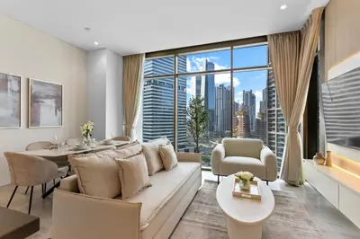 a living room with a couch and a large window at Sleek 1Bedroom with Burj Khalifa view in Peninsula in Dubai