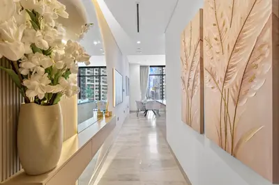 a hallway with a vase of flowers on a wall at Sleek 1Bedroom with Burj Khalifa view in Peninsula in Dubai