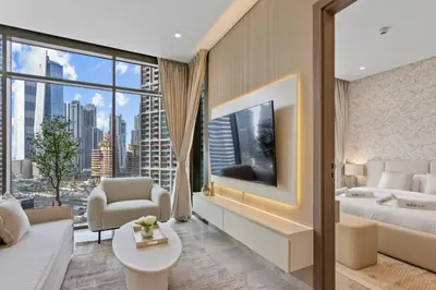 a living room with a bed and a large window at Sleek 1Bedroom with Burj Khalifa view in Peninsula in Dubai