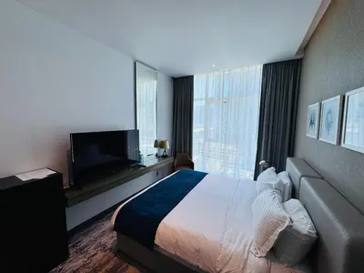a hotel room with a bed and a flat screen tv at Maison Prive By DAMAC Studio in Dubai