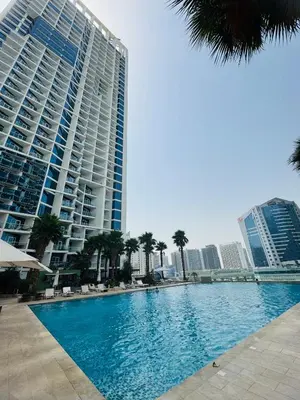 a swimming pool in front of a large building at Maison Prive By DAMAC Studio in Dubai