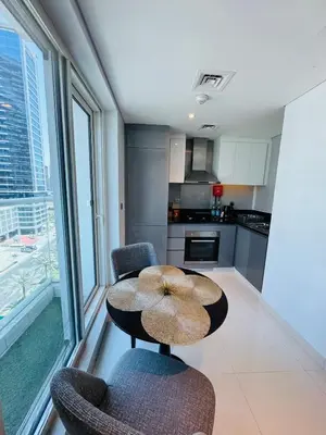 a kitchen with a table and two chairs in a room at Maison Prive By DAMAC Studio in Dubai