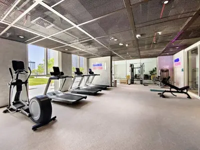 a gym with a row of treadms and cardio machines at Modern 1BR Retreat in Dubai Hills Prime Location in Dubai