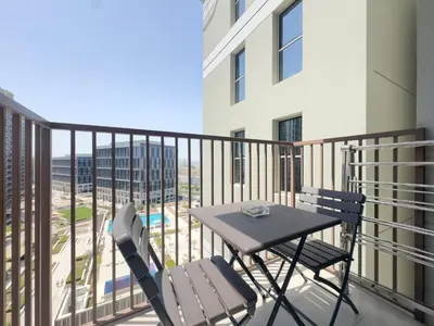a table and chairs on a balcony with a view at Modern 1BR Retreat in Dubai Hills Prime Location in Dubai