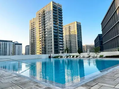 a large swimming pool in a city with tall buildings at Modern 1BR Retreat in Dubai Hills Prime Location in Dubai