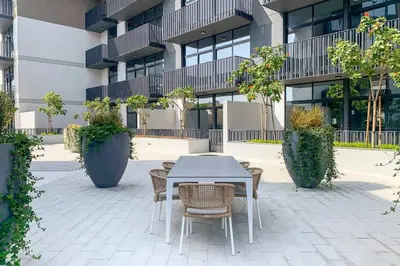 a table and chairs in front of a building at Amazing 1BR with Pool in JVC in Dubai