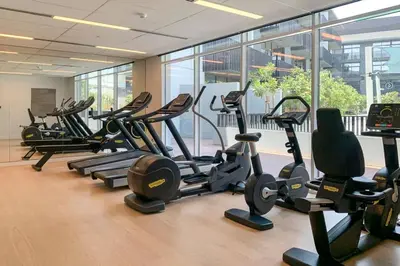 a gym with a bunch of treadms and cardio machines at Amazing 1BR with Pool in JVC in Dubai