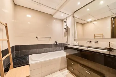 a bathroom with a tub and a sink and a mirror at 2BR at Lofts West Near Dubai Mall and Burj Khalifa in Dubai