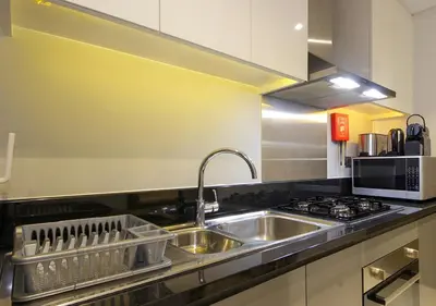 a kitchen with a sink and a stove at Modern Living DAMAC with Balcony & Waterfront Views in Dubai