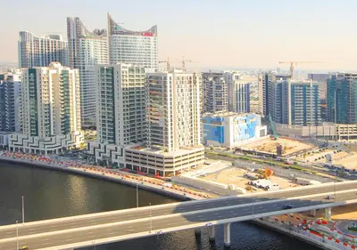 a city with a highway and a bridge and buildings at Modern Living DAMAC with Balcony & Waterfront Views in Dubai