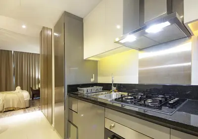 a kitchen with a stove and a sink at Modern Living DAMAC with Balcony & Waterfront Views in Dubai